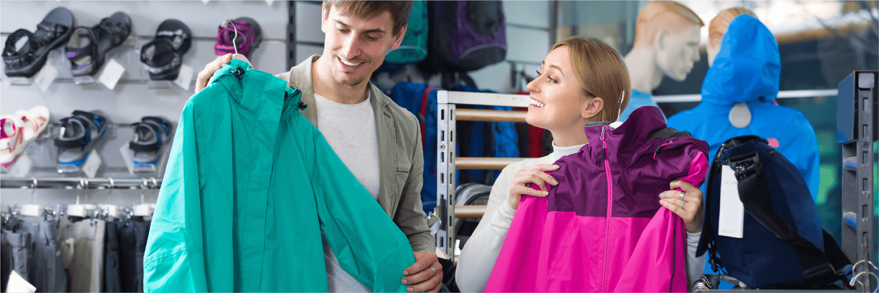 happy couple shopping for waterproof coats